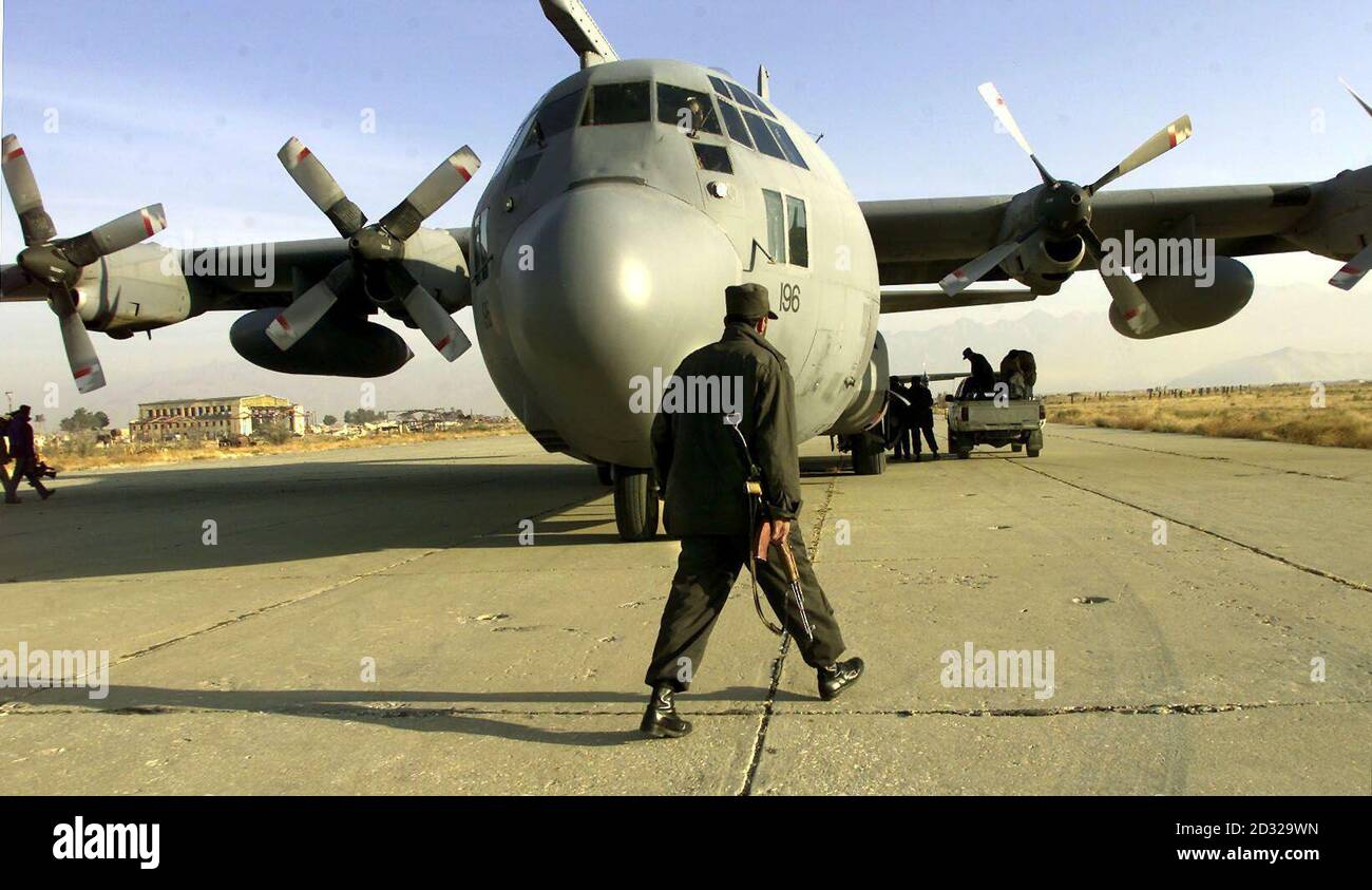 Un soldato afghano all'aeroporto di Bagram, fuori Kabul, si avvicina all'aereo britannico RAF Hercules, che ha volato undici membri della delegazione afghana nella prima tappa del viaggio verso la conferenza, che avrà inizio a Bonn. Foto Stock