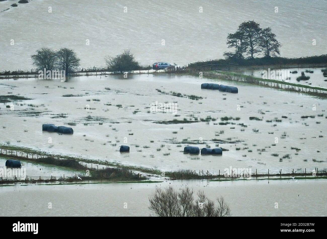 Un veicolo riesce ad attraversare i livelli sommersi del Somerset mentre la pioggia continua a cadere su campi già coltivati e fiumi gonfi nella zona. Foto Stock