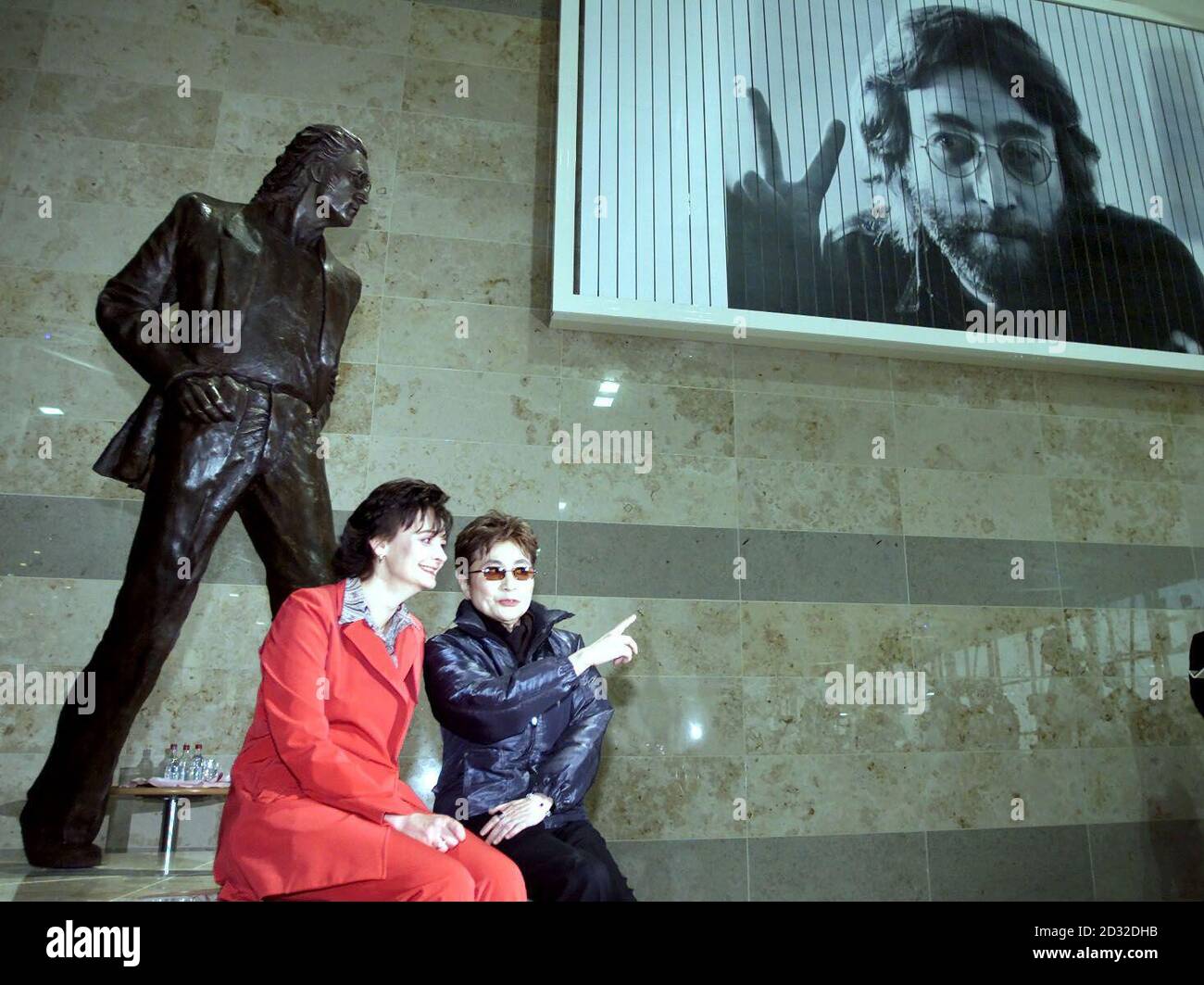 Yoko Ono, la vedova dell'ex Beatle John Lennon, svela una statua del suo defunto marito accanto a Cherie Booth sull'atrio superiore dell'aeroporto John Lennon di Liverpool. La statua è opera dello scultore Tom Murphy. Foto Stock