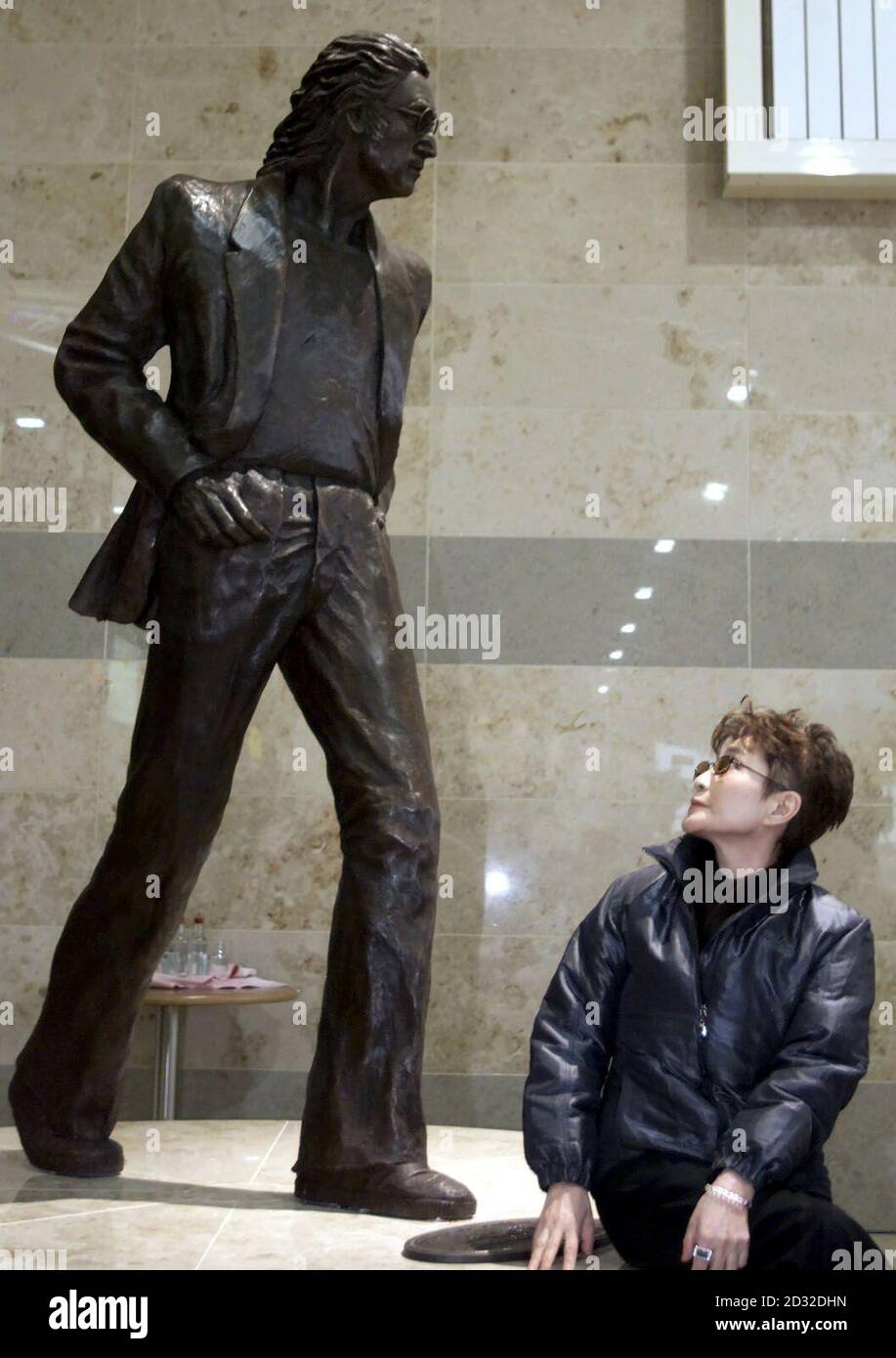 Yoko Ono, la vedova dell'ex Beatle John Lennon, svela una statua del suo defunto marito sull'atrio superiore dell'aeroporto John Lennon di Liverpool. È stata unita alla presentazione con Cherie Booth. La statua è opera dello scultore Tom Murphy. Foto Stock
