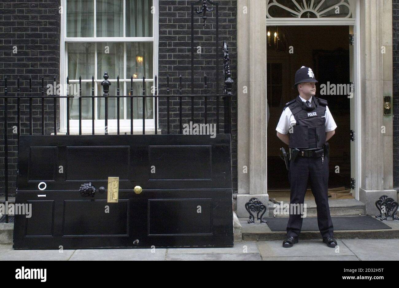 La famosa porta d'ingresso del 10 Downing Street, la recidence ufficiale di Londra del primo Ministro britannico, è stata rimossa per un nuovo strato di vernice. La porta viene sostituita con una replica esatta per un anno in cui il processo viene ripetuto. Foto Stock