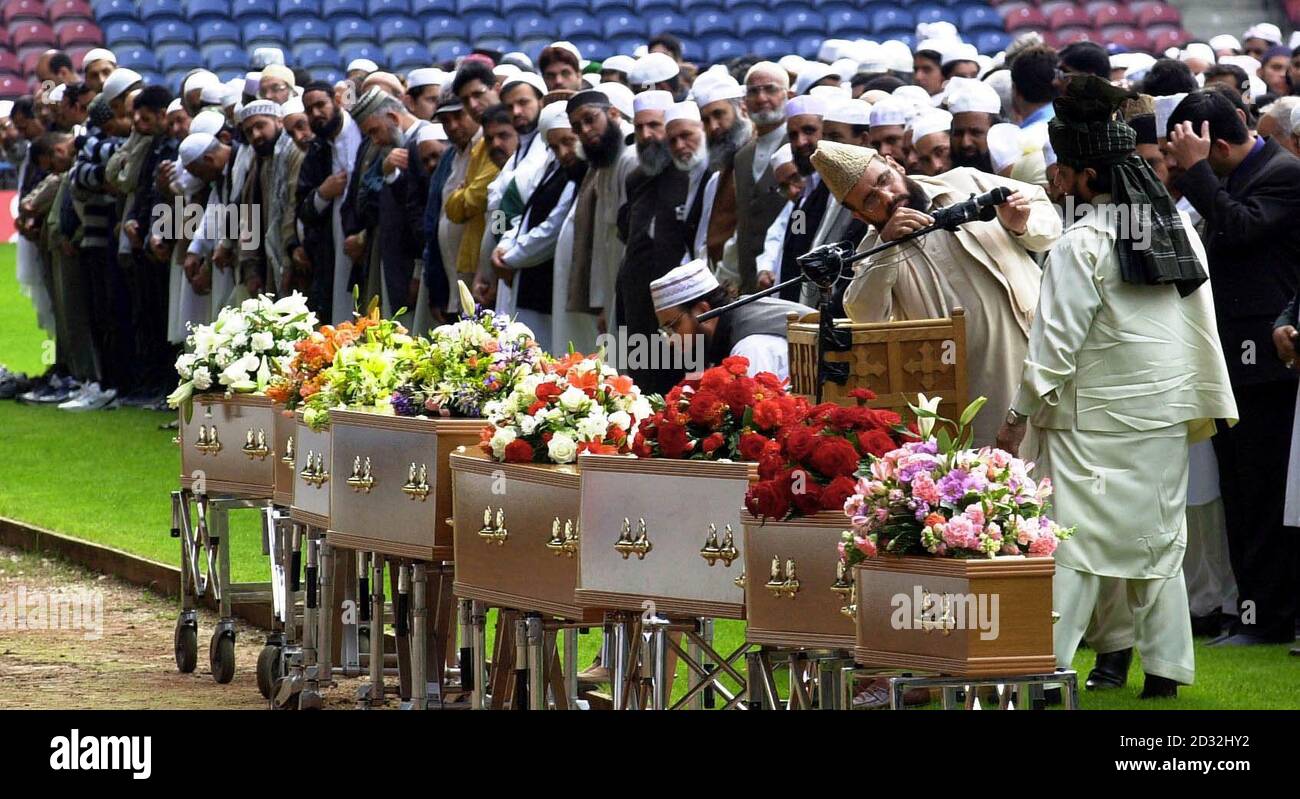 I cordoglio si preparano per le preghiere davanti alle casse dello Stadio McAlpine di Huddersfield durante il servizio commemorativo multi-fede per otto membri della stessa famiglia asiatica uccisi in un attacco di arson. Cinque giovani sorelle morirono accanto alla madre, allo zio e alla nonna. * dopo che un blaze si è strappato attraverso la loro casa a Birkby, Huddersfield, nelle prime ore del 12 maggio 2002. Coloro che morirono nel blaze furono Mohammed Ateeq-ur-Rehman, sua sorella Nafeesa Aziz e le sue cinque figlie - Tayyaba Bootall, 13, Rabiah Bootall, 10, Ateeqa Nawaz, Sei, Anesa Nawaz, due, e Najeeba Nawaz, sei mesi. Th Foto Stock