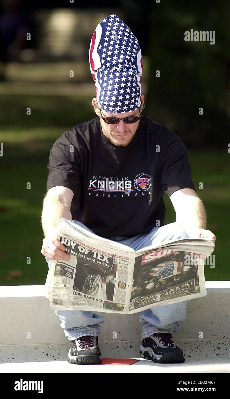 Un uomo che indossa un cappello a stelle e strisce legge un giornale al Memorial fuori dell'ambasciata americana in Grosvenor Square a Londra a coloro che sono morti in attacchi terroristici a New York, Washington e Pennsylvania. * altrove, il Principe di Galles, il Principe Harry, il primo Ministro e altri VIP stavano partecipando ad un servizio di memoria e commemorazione alla cattedrale di San Paolo. Foto Stock