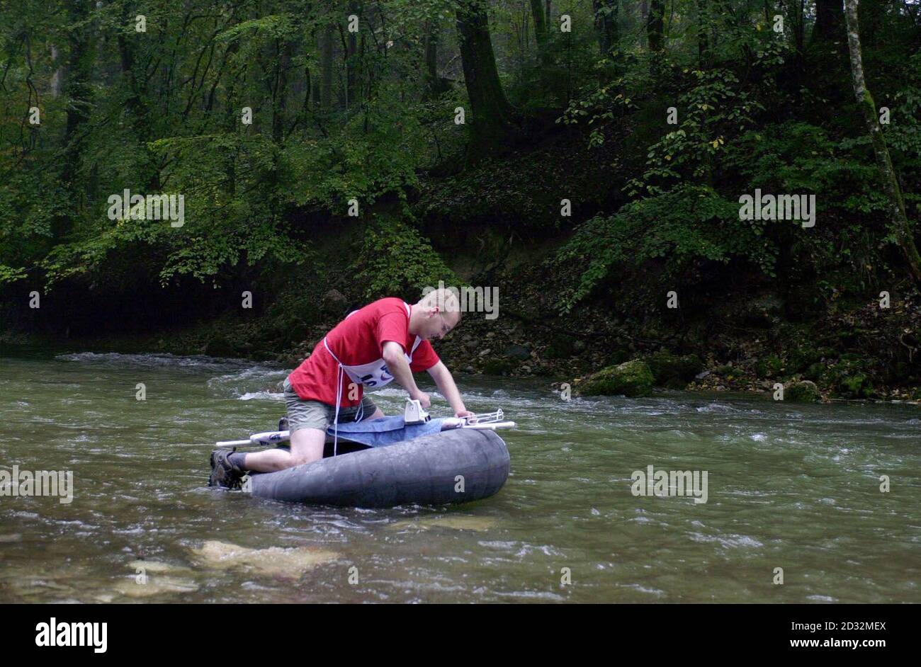 David Fitzgerald, noto anche come 'Safety Setting', 26, un responsabile della salute ambientale di Chichester, ferra una camicia durante la sezione acqua dei campionati mondiali di ferro estremo che si tengono vicino Monaco di Baviera in Germania. *... David è uno dei 12 concorrenti del Regno Unito, sponsorizzato da Rowenta, in quello che è il primo campionato mondiale che si tiene nello sport. Il compagno di squadra Phil 'team' Shaw inventò lo sport nel 1997 quando decise di combinare il lavoro mondano della stiratura con il suo amore per l'arrampicata. I campionati consistono in cinque discipline tra cui foresta, urbano, stile libero e roccioso con circa dieci paesi Foto Stock