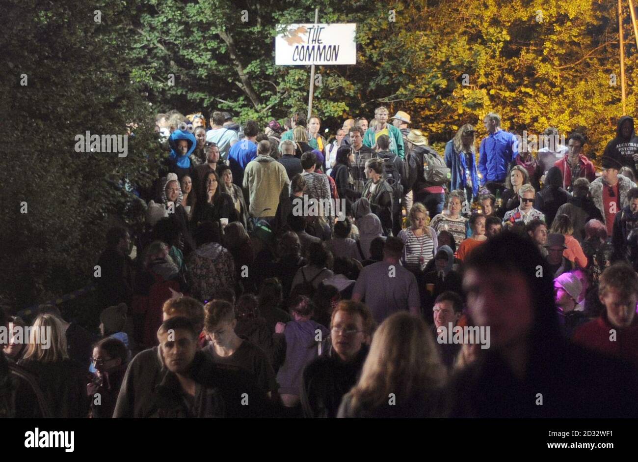 I festaioli camminano attraverso il comune durante il Festival delle arti dello spettacolo contemporanee di Glastonbury 2013 a Pilton Farm, Somerset. Foto Stock