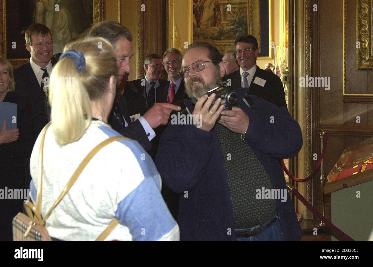 Il Principe Carlo guarda una fotografia di se stesso scattata da un membro del pubblico durante un tour del Castello di Windsor. Nel tentativo di incrementare il turismo, l'erede al trono ha fatto il giro del castello di sua madre con i dirigenti di viaggio. Foto Stock
