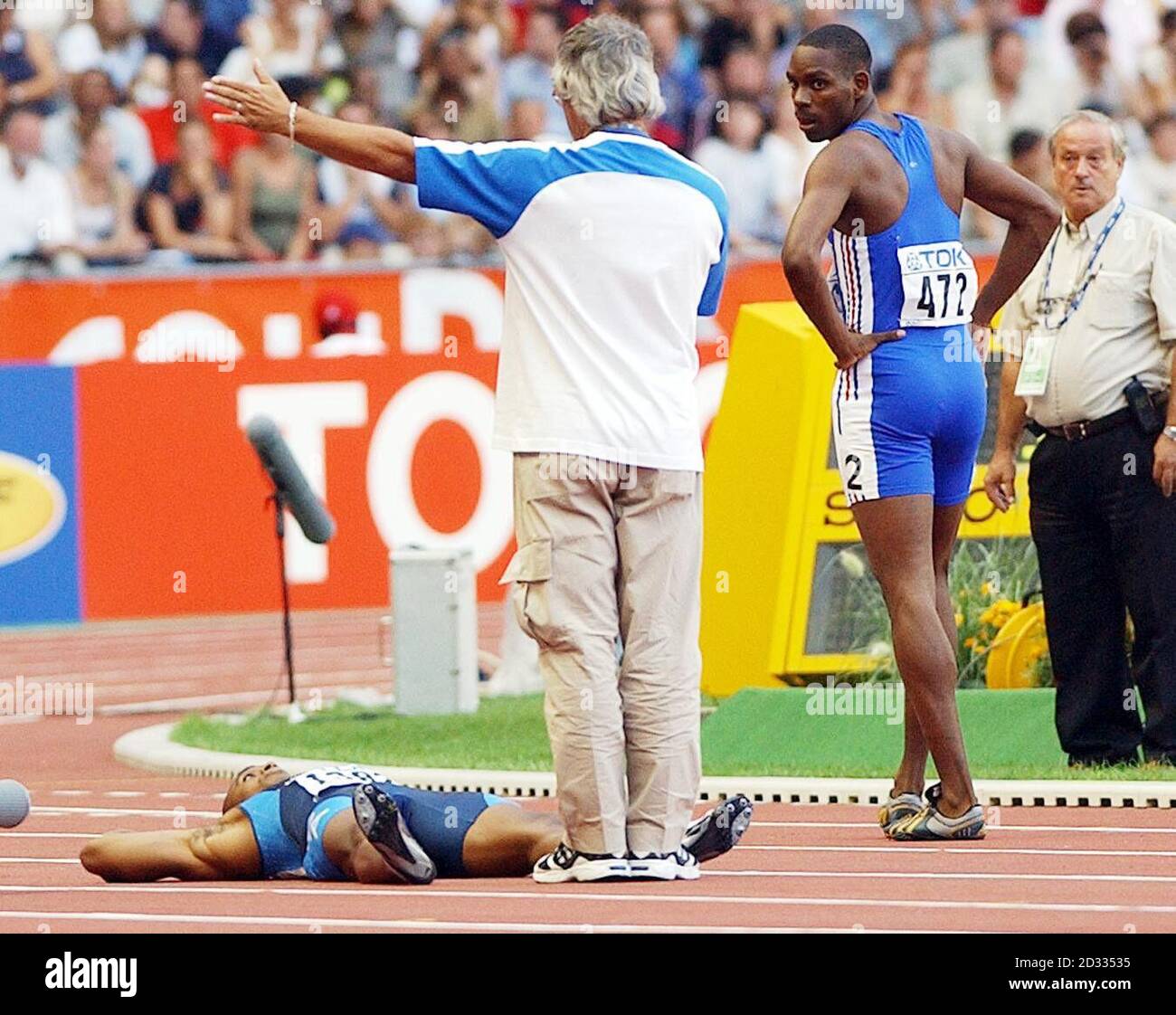 Jon Drummond (in basso) degli Stati Uniti si trova sulle sue spalle, rifiutandosi di scendere dalla pista dopo essere stato squalificato nel quarto finale dei 100 metri degli uomini ai Campionati mondiali di atletica di Parigi, Francia, domenica 24 agosto 2003. Foto Stock