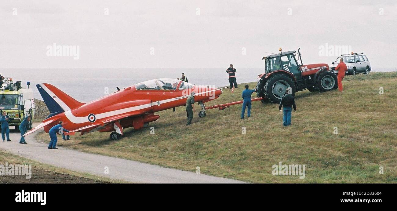 I tecnici di aeromobili utilizzano un trattore per recuperare un aereo RAF Red Arrows che ha superato l'estremità occidentale della pista all'aeroporto di Jersey. Nessuno dei due membri dell'equipaggio di Hawk, con base a RAF Scampton nel Lincolnshire, che stava arrivando a Jersey per intraprendere esposizioni nella zona più tardi questa settimana, è stato ferito. Foto Stock