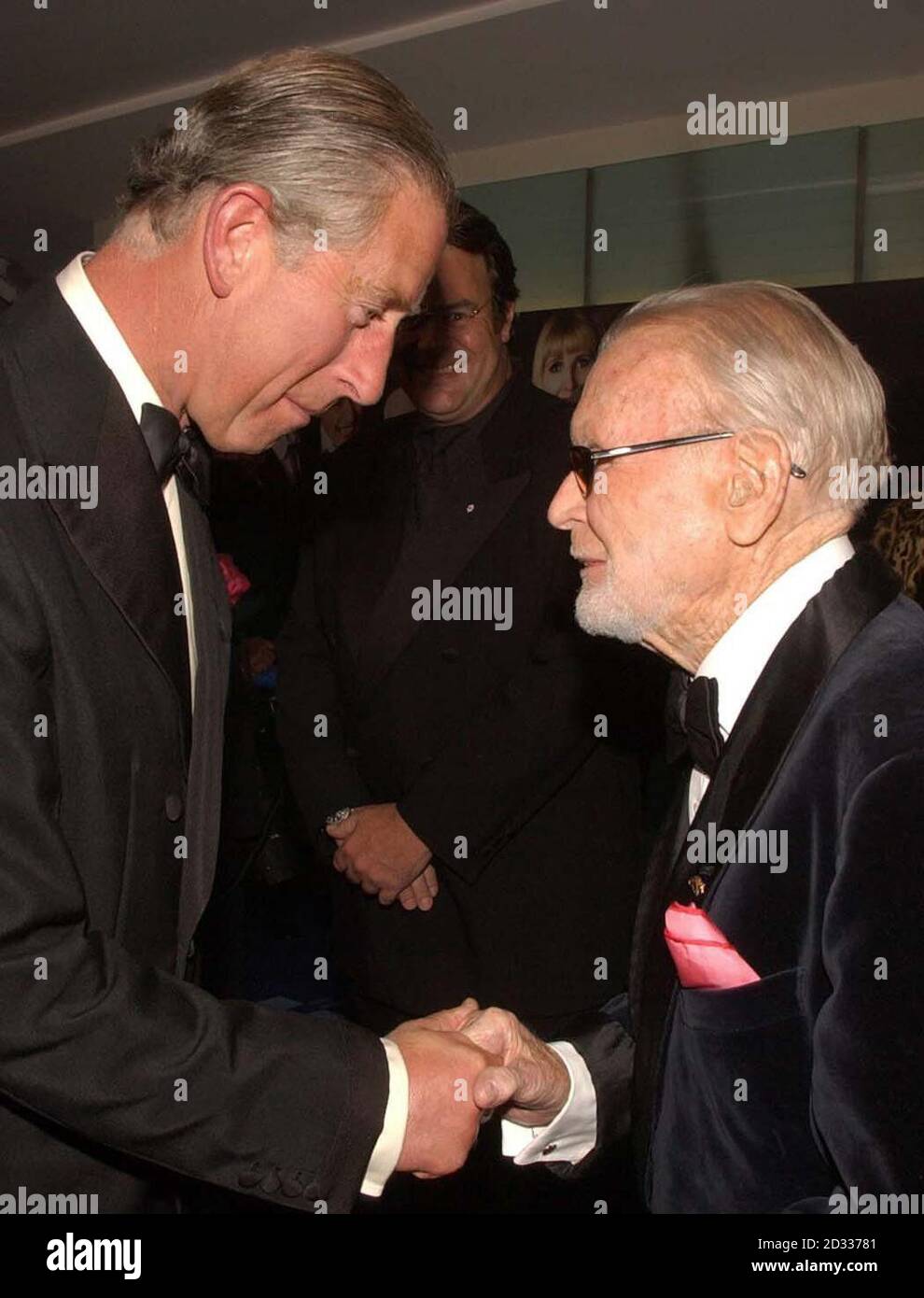 Il Principe del Galles incontra Sir John Mills (a destra) a Odeon, Leicester Square, nel centro di Londra, per la prima assoluta del film "Bright Young Things", tenuto in aiuto della fiducia del Principe. Foto Stock