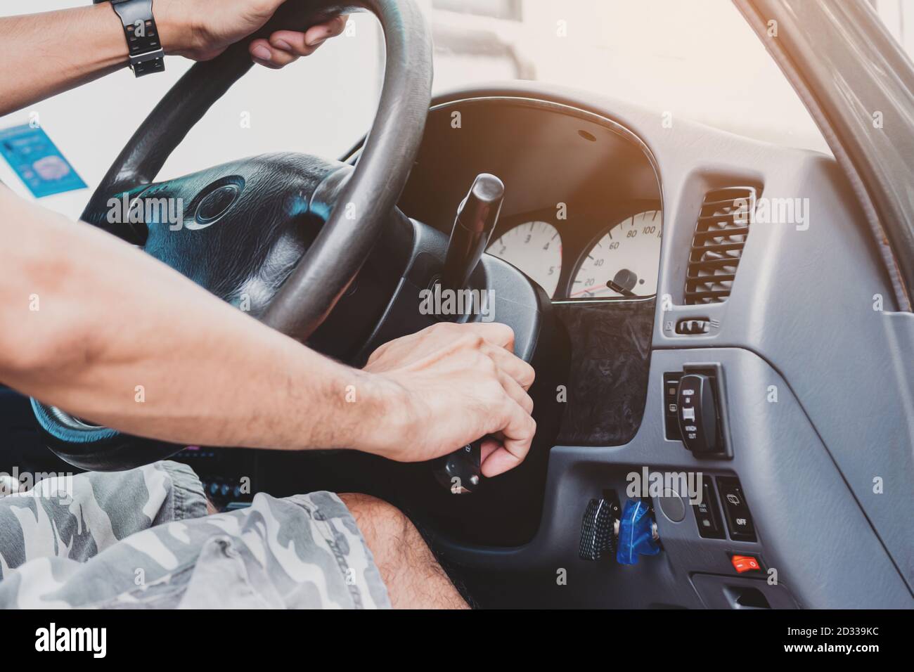 Primo piano della mano di un uomo con la chiave per avviare i concetti del settore del motore, dei trasporti e delle assicurazioni dell'auto. Foto Stock