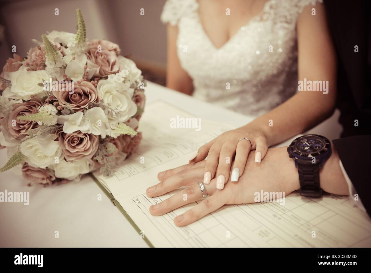Coppia di nozze che mostra gli anelli di nozze sul registro di matrimonio di nozze Foto Stock
