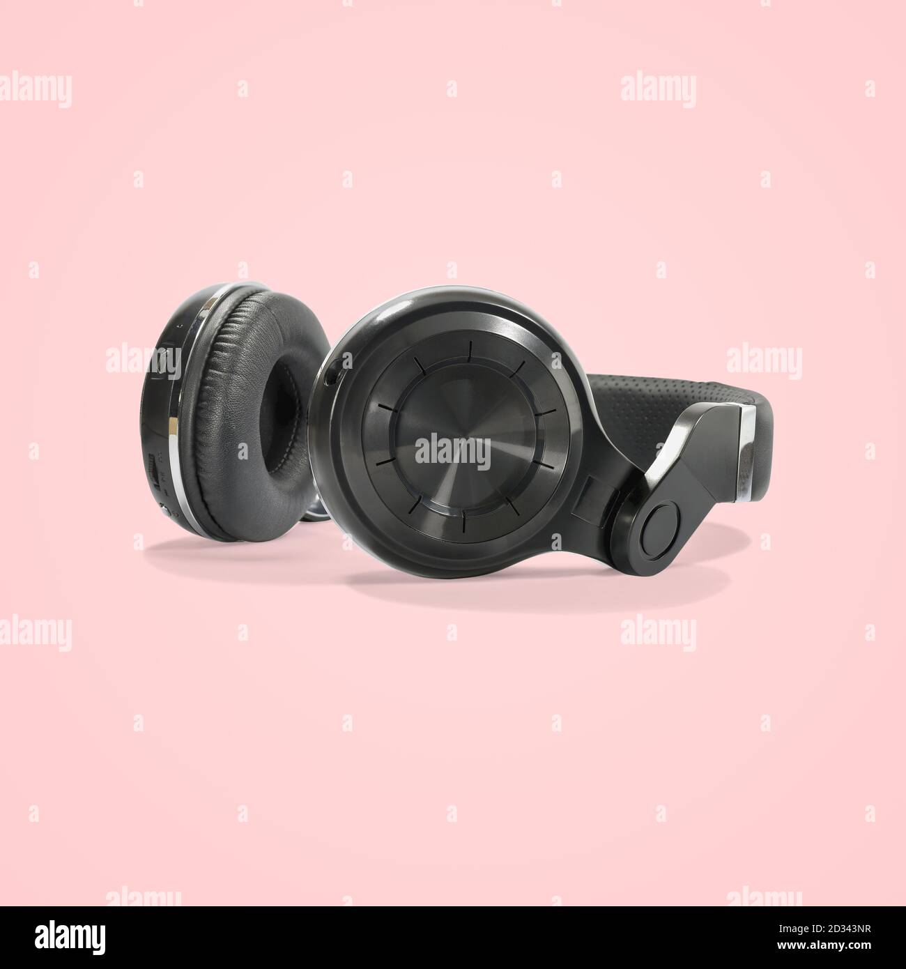 Le cuffie wireless nere sono isolate su uno splendido sfondo color pastello, con un percorso di ritaglio. Foto Stock