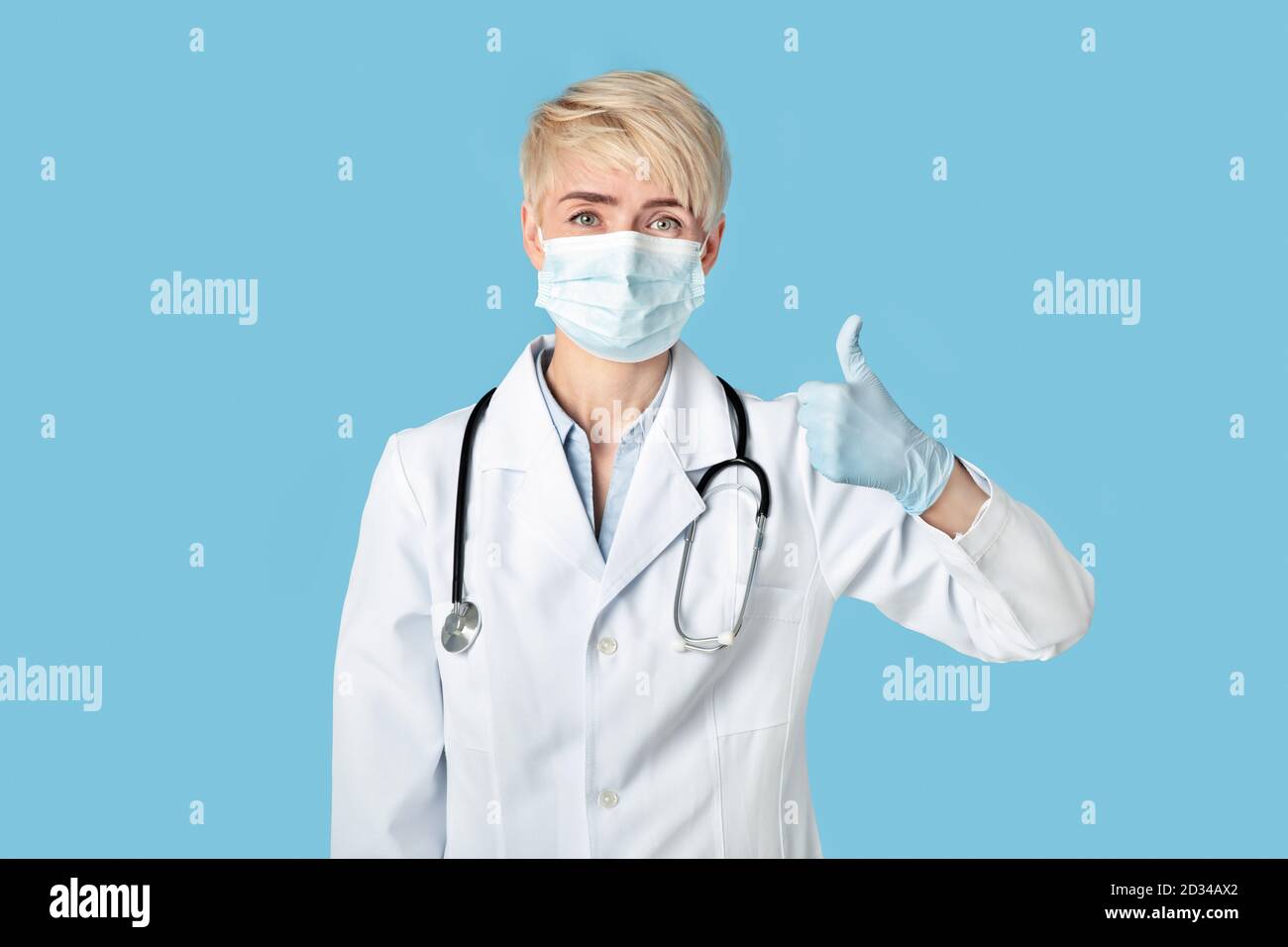 Grande assistenza medica, prevenire le malattie e la quarantena. Il medico della donna di mezza età nei guanti di gomma mostra i pollici in su Foto Stock