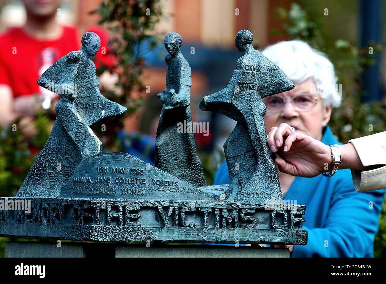 La gente di Bradford si riunisce intorno ad una statua nel centro della città, per ricordare le 56 persone uccise al fuoco del Bradford City Football Club 20 anni fa. Foto Stock