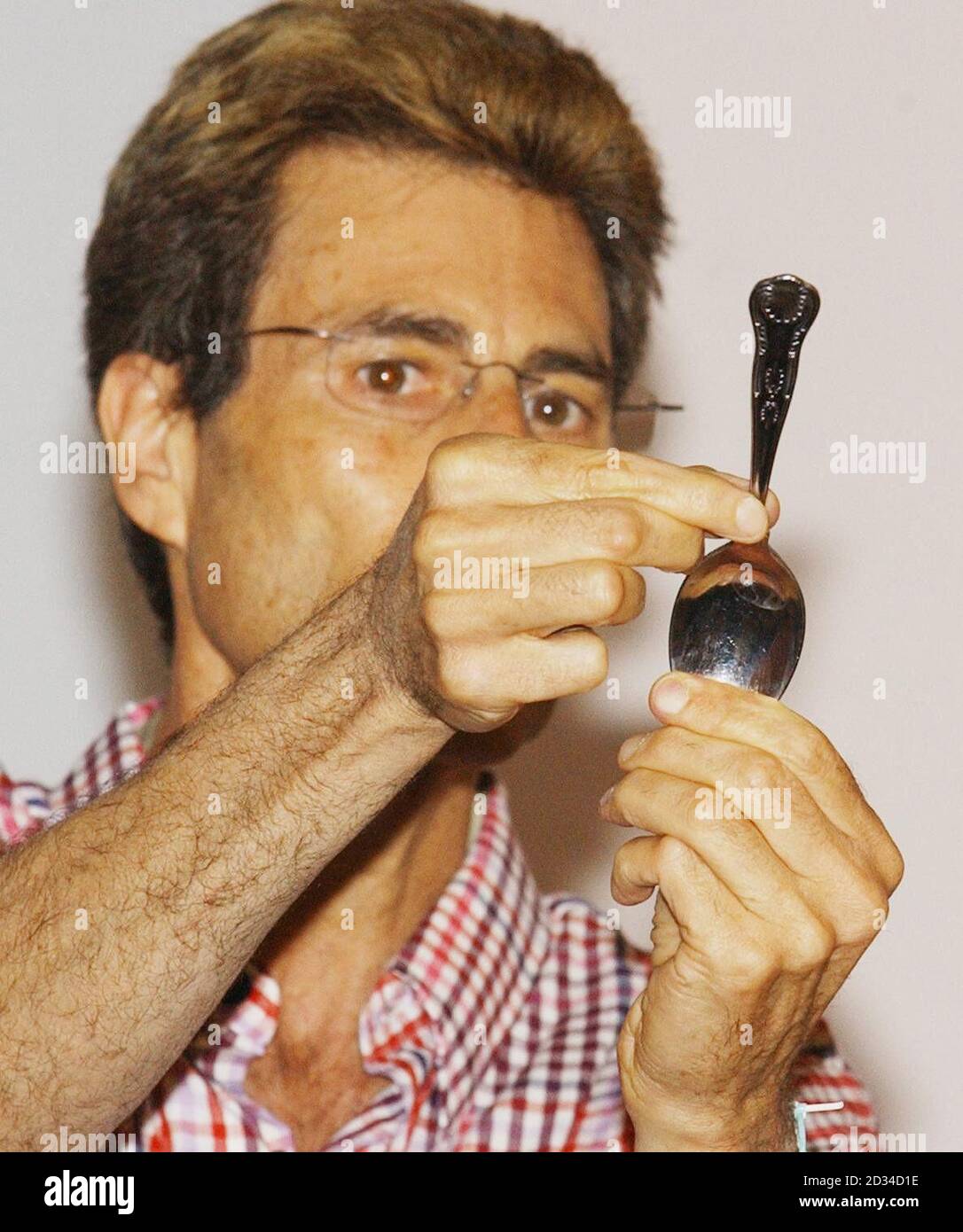 URI Geller dà una dimostrazione di piegatura del cucchiaio prima di rompere lo champagne sopra la prua della barca di Dom Mee a Exmouth. L'eccentrico avventuriero Mee ha annunciato oggi la sua ultima bizzarra stunt, per attraversare l'Atlantico settentrionale nell'unica barca al mondo alimentata da aquiloni. L'ex comandante reale della Marina Mee, 34, ha in programma di stabilire un nuovo record mondiale quando salpa nella sua piccola barca il 15 agosto. Mee, da West Buckland, vicino a Wellington, Somerset, salperà da St Johns a Terranova, Canada. Foto Stock