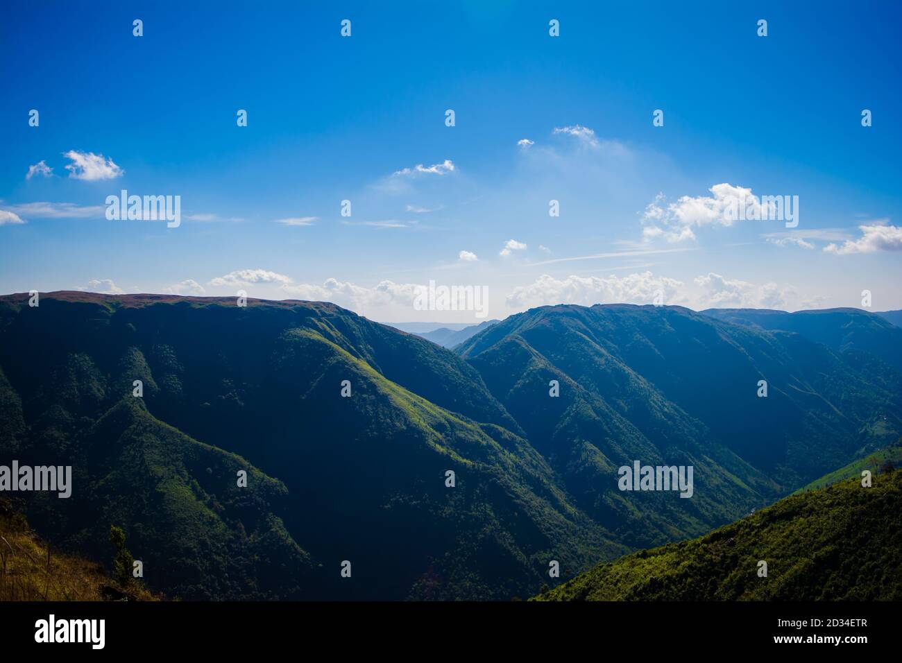 Vista naturale delle montagne ripiegate e delle verdi valli lussureggianti con cielo limpido e nuvole di Cherrapunji, Megalaya, India del Nord Est Foto Stock