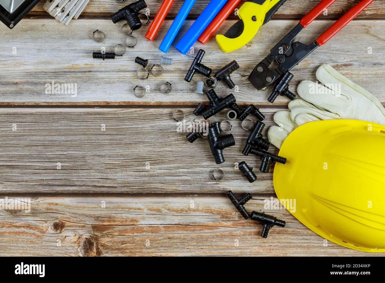 Vista dall'alto degli attrezzi idraulici sui raccordi per tubi flessibili attrezzi idraulici materiali tra cui tubo in rame, giunto a gomito, chiave per chiave per idraulico principale Foto Stock