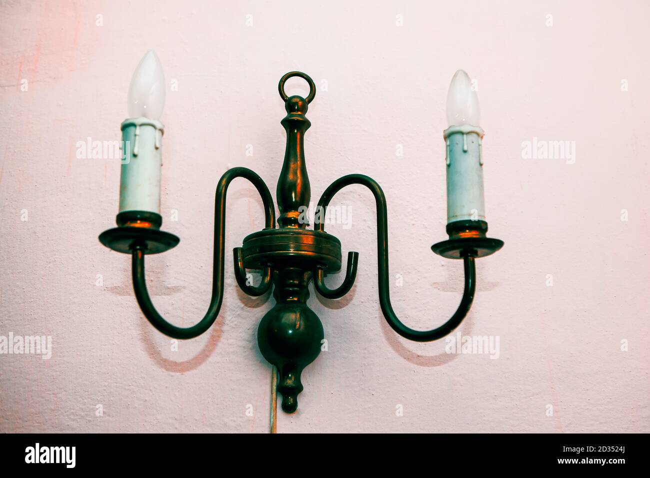 Lampada elettrica a candela sulla parete bianca Foto Stock