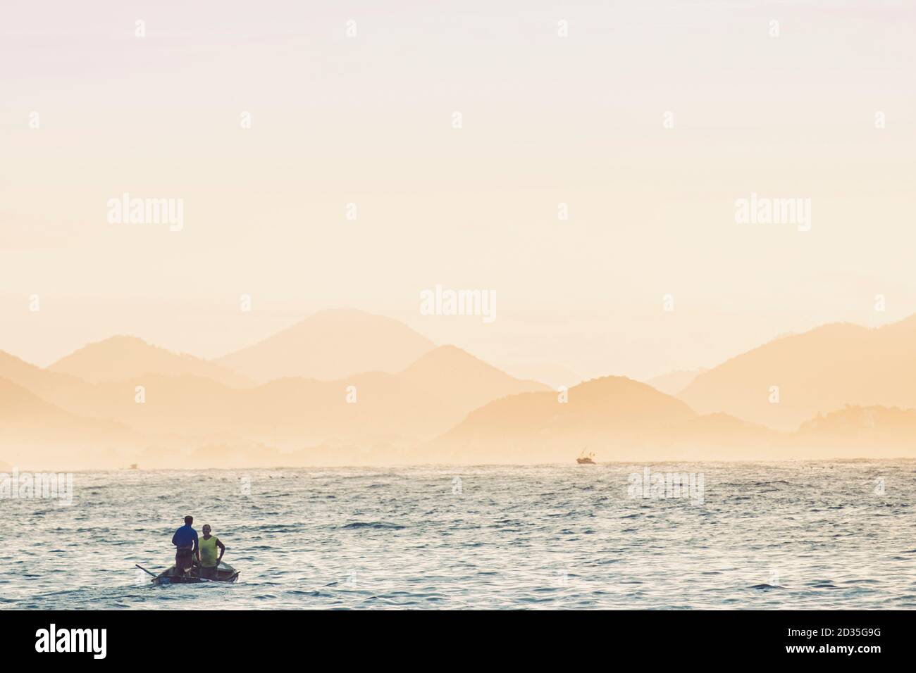 Barca da pesca su una baia di acque calme, colline lontane, luce dell'alba, scena idilliaca, Sud America Foto Stock