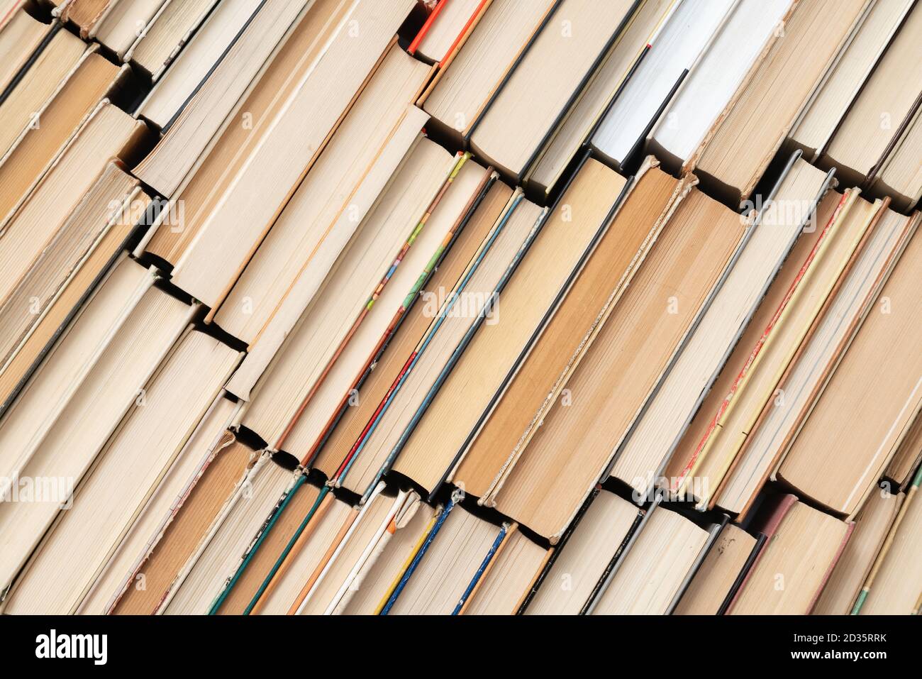 Sfondo del libro d'epoca. Libri vecchi e usati di hardback impilati uno accanto all'altro. Concetto di istruzione e di studio. Nessuno Foto Stock