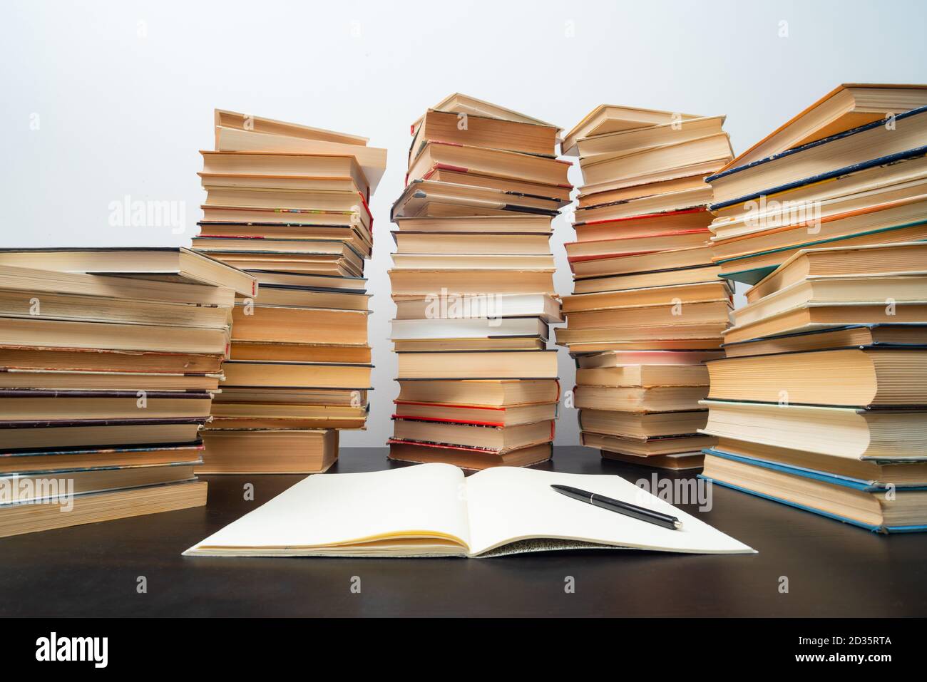 Grande pila di libri sul tavolo. Studiare prima dell'esame. Pila di libri d'epoca. Concetto di istruzione e di studio Foto Stock