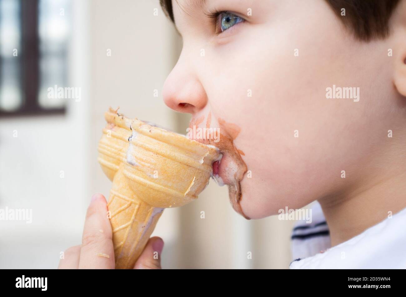 5 anni piccolo gelato a doppio cono leccante. Messa a fuoco selettiva Foto Stock