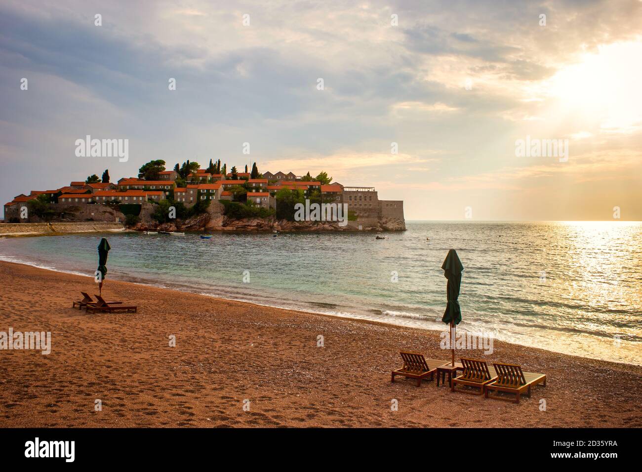 Sveti Stefan storico isola cittadina e paradiso spiaggia di sabbia al tramonto. Budva riviera, Montenegro (mare Adriatico), Europa. Concetto di viaggio, sfondo. Foto Stock