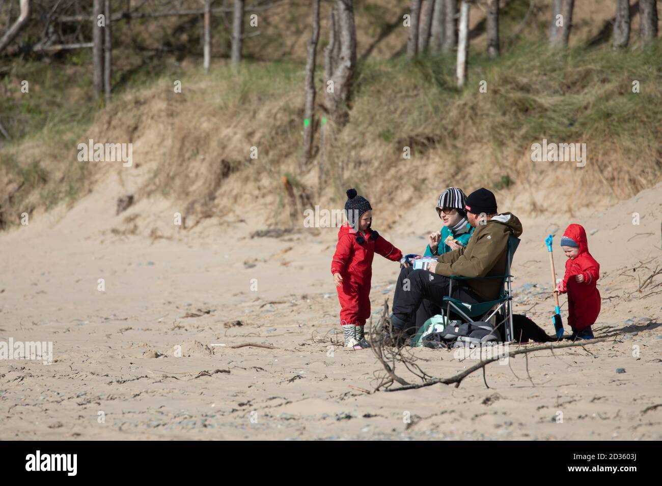 Newborough, Anglesey, Galles del Nord, Regno Unito. Regno Unito Meteo: 7 ottobre 2020 una bella giornata calda su Anglesey tra i fronti meteo, con un altro fronte di pioggia previsto per colpire il Regno Unito il Venerdì. Una famiglia che approfitta di una giornata senza pioggia a Newborough Beach, Anglesey © DGDImages/AlamyNews Foto Stock