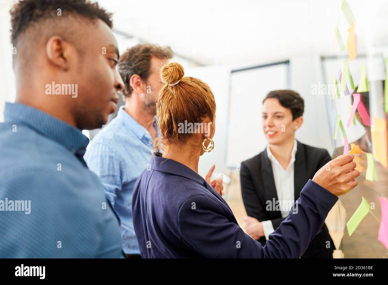Giovane team creativo nel seminario di brainstorming con note appiccicose durante la valutazione Foto Stock