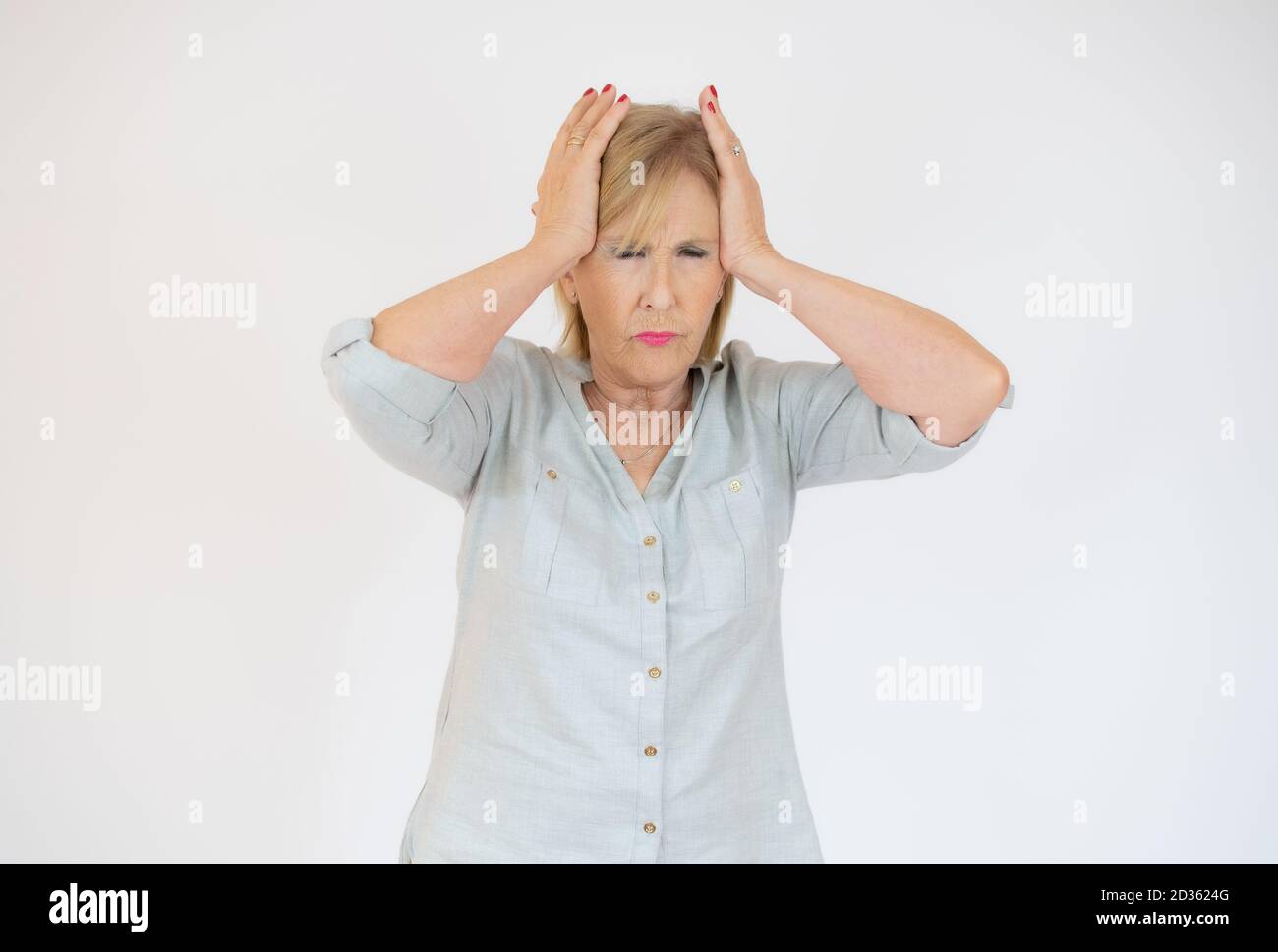 Donna anziana che ha mal di testa e che tocca i suoi templi isolati su sfondo bianco. Foto Stock