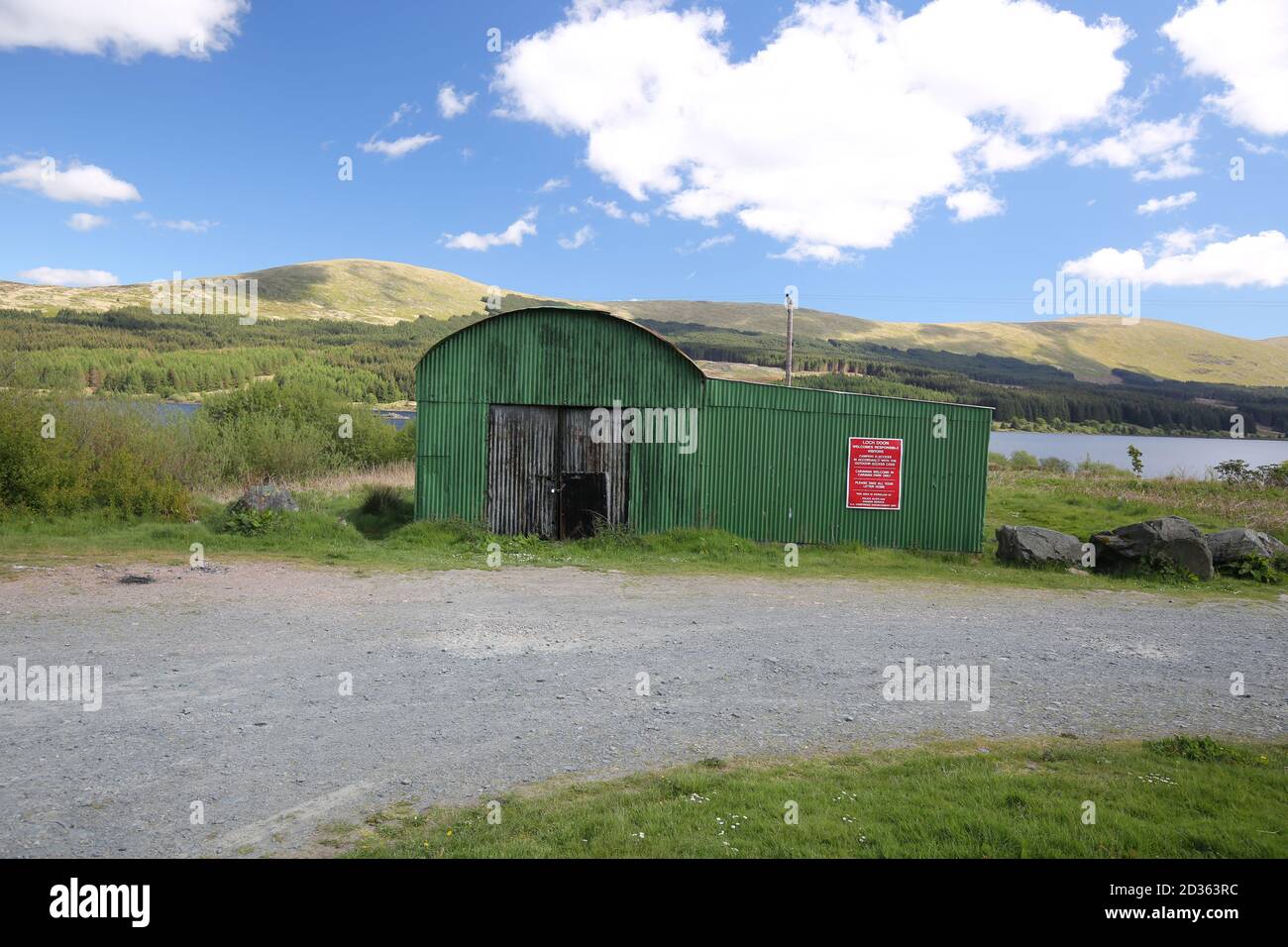 Loch Doon, Ayrshire, Scozia, UK UN capannone di metallo corrugato verde che guarda dispari contro la bellezza di Ayrshire Foto Stock