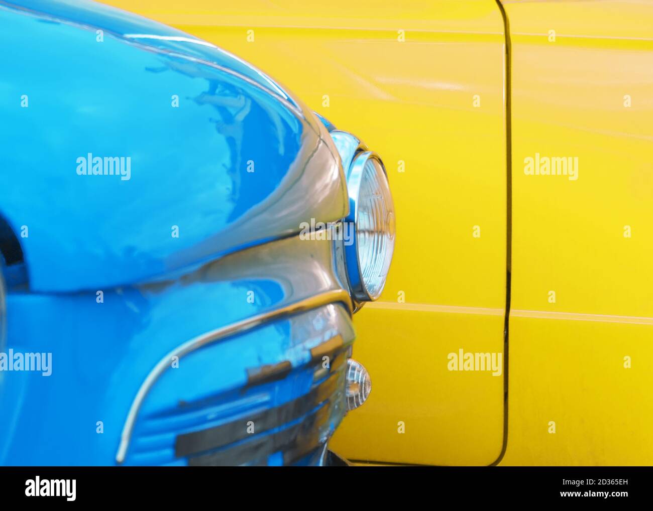Faro di un'auto vintage blu sullo sfondo di un primo piano auto giallo Foto Stock