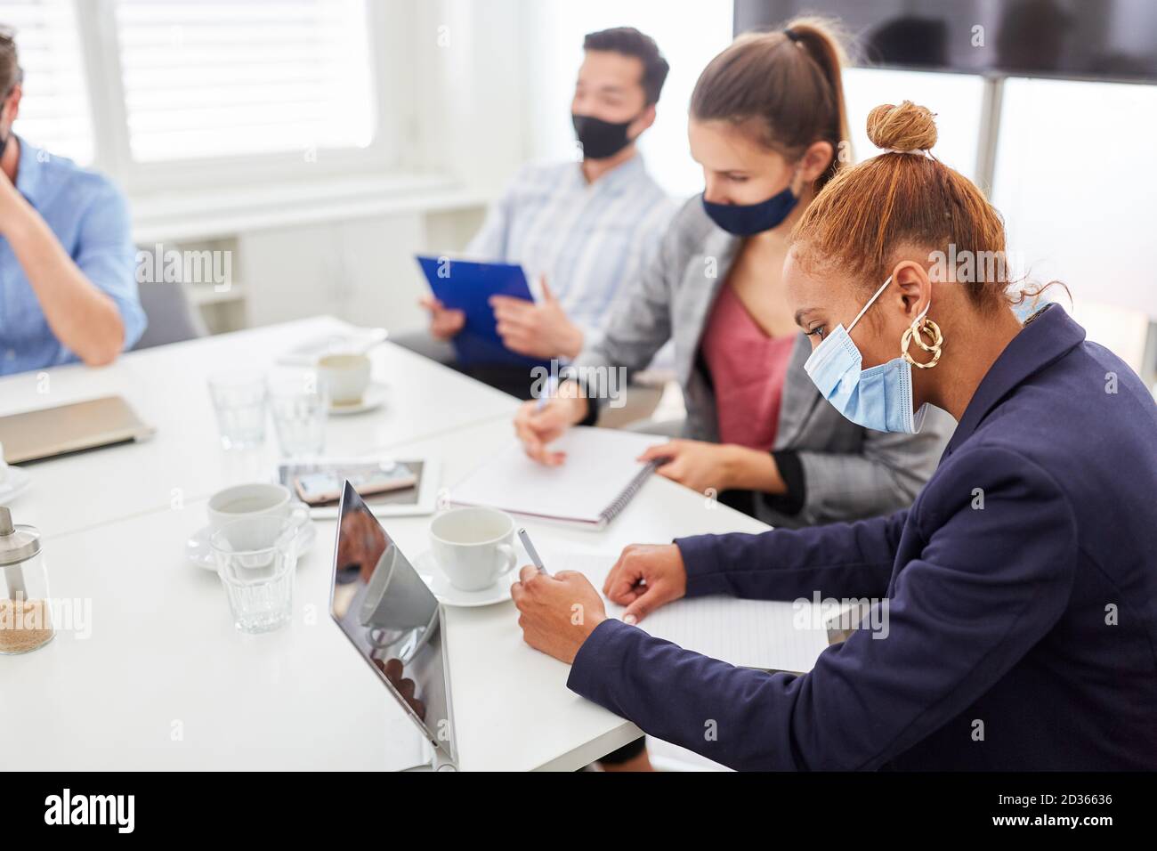 Giovane donna d'affari prende appunti in un seminario o un seminario Foto Stock