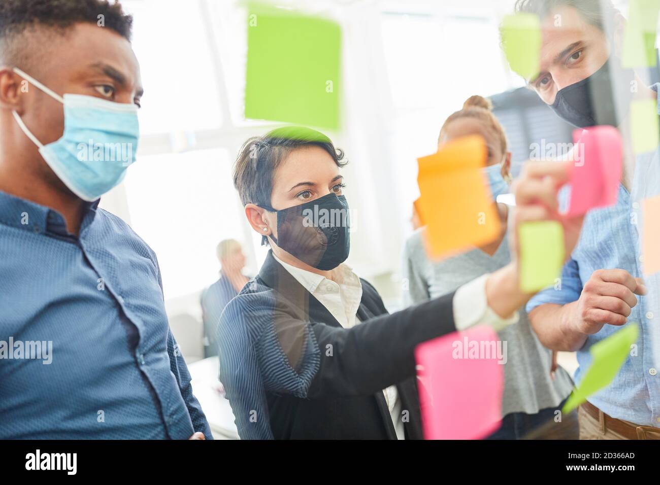 Team aziendale creativo con note appiccicose sul vetro nel brainstorming seminario Foto Stock