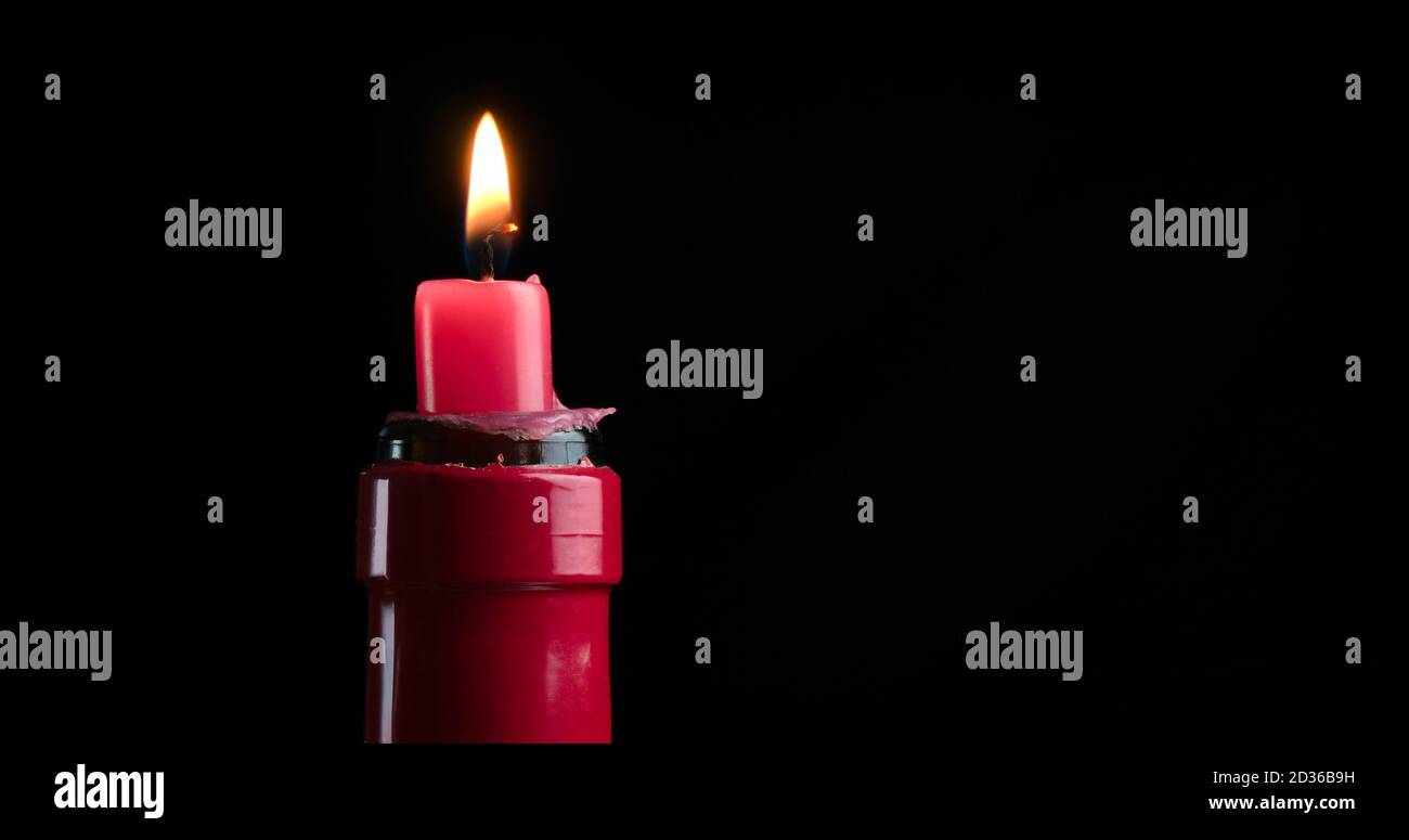 candela rossa in una bottiglia di vino rosso Foto Stock