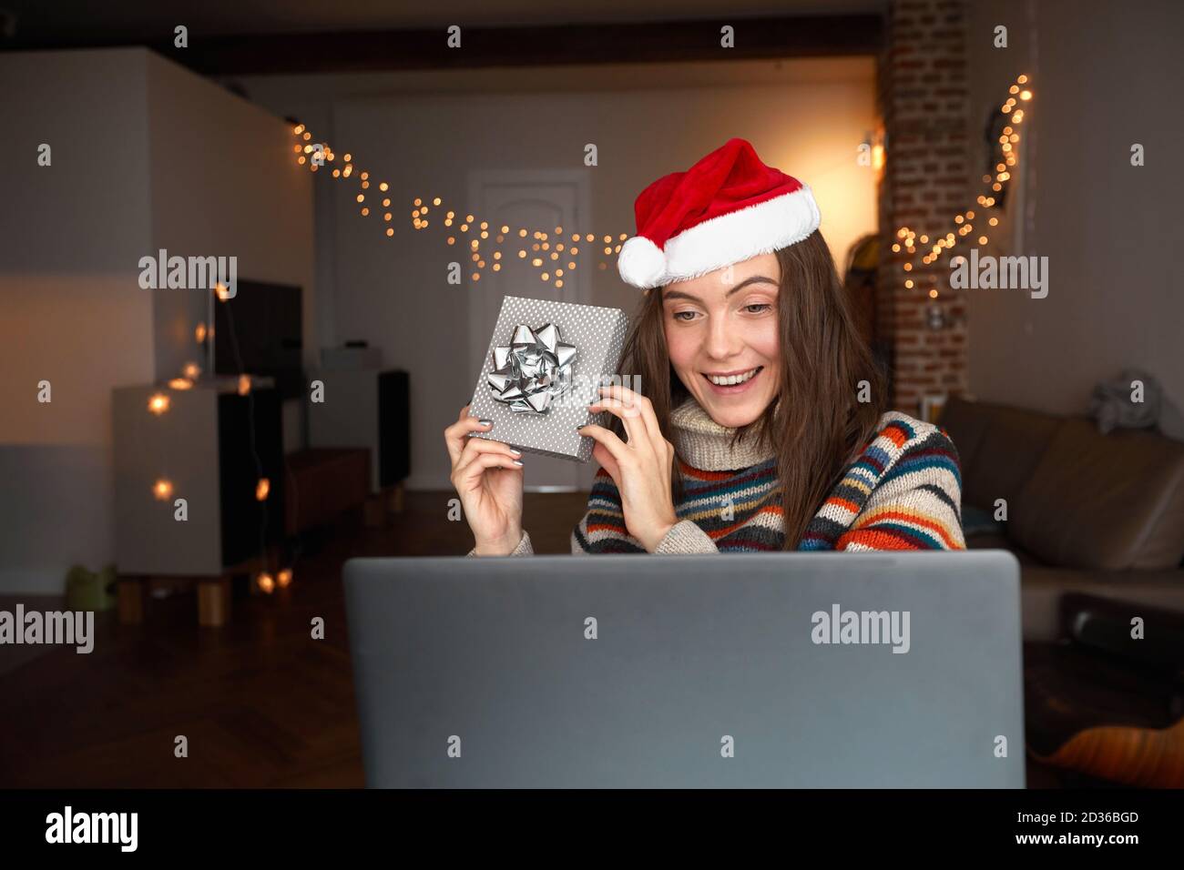 Donna felice che fa la videochiamata durante la celebrazione di Natale Foto Stock