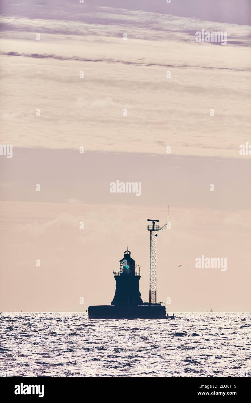 Silhouette di un beacon al tramonto, messa a fuoco selettiva, tonalità colore applicate. Foto Stock