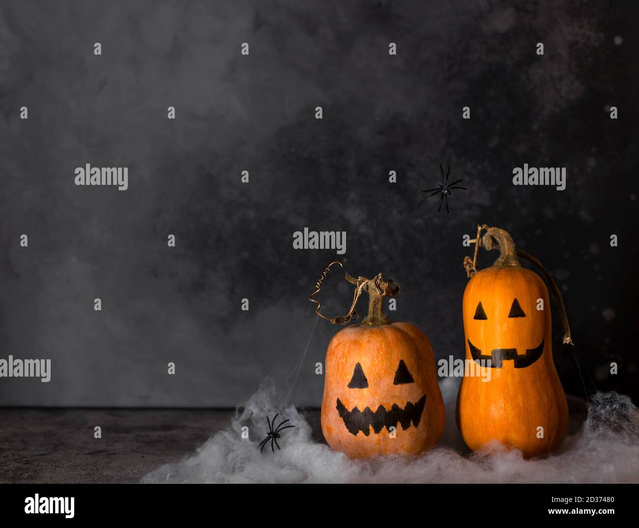 Zucche di Halloween con facce dipinte e ragnatela con appendere ragni Foto Stock