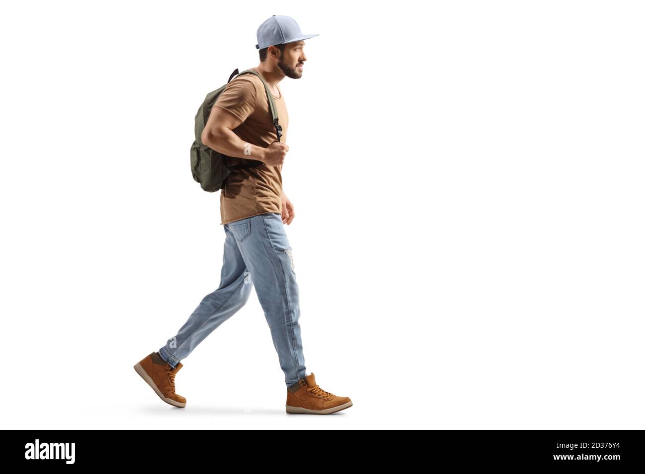 Foto di profilo a lunghezza intera di un ragazzo con uno zaino e jeans strappati che camminano isolati su sfondo bianco Foto Stock