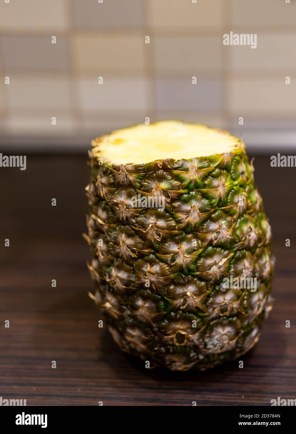 Primo piano di un ananas con una parte superiore tagliata, un ingrediente gustoso per succo o frullato Foto Stock
