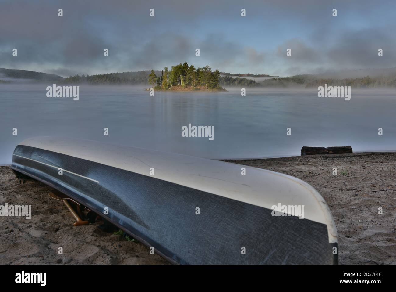 La mattina presto nebbia solleva dal lago, con acqua liscia nel remoto nord dell'Ontario, Canada. Foto Stock La mattina presto nebbia solleva dal lago, con acqua liscia nel remoto nord dell'Ontario, Canada. Foto Stock