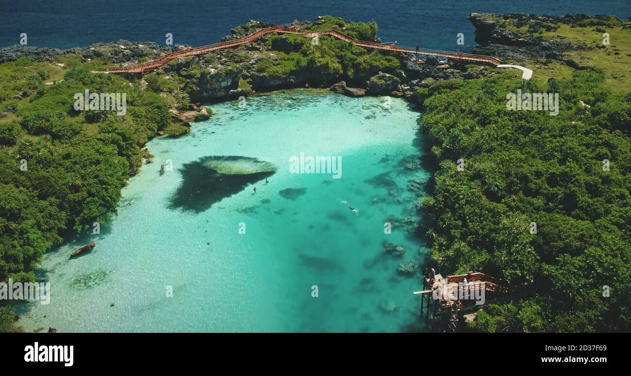 Lago di acqua salata in verde paesaggio tropicale con piante, alberi, erba della laguna Weekuri, Isola di Sumba Indonesia, Asia. Maestosa vacanza estiva ricreazione al lago di acqua salata sulla scogliera costa dell'oceano Foto Stock