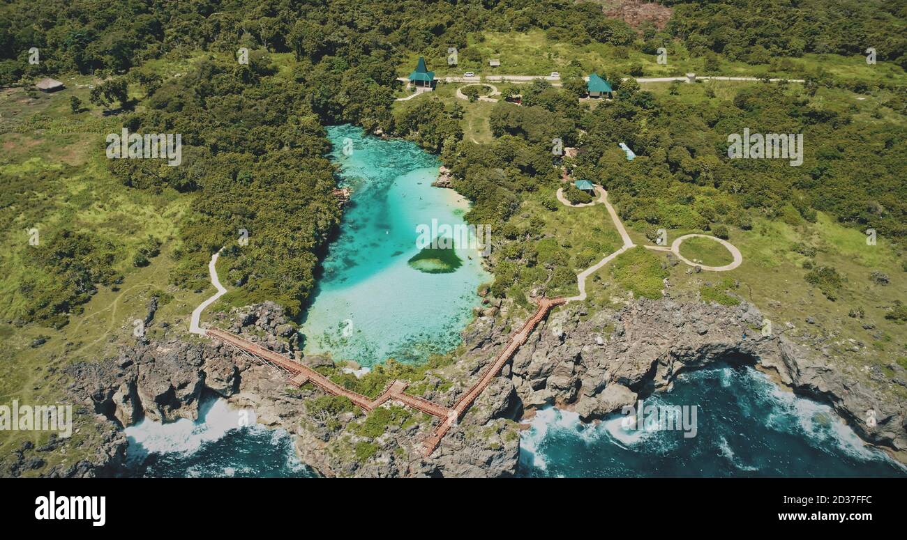 Lago d'acqua salata con vista aerea del paesaggio tropicale verde. Estate nessuno scenario naturale di Weekuri punto di riferimento, Isola di Sumba, Indonesia, Asia. Laguna limpida con verde foresta tropicale sull'oceano roch costa Foto Stock