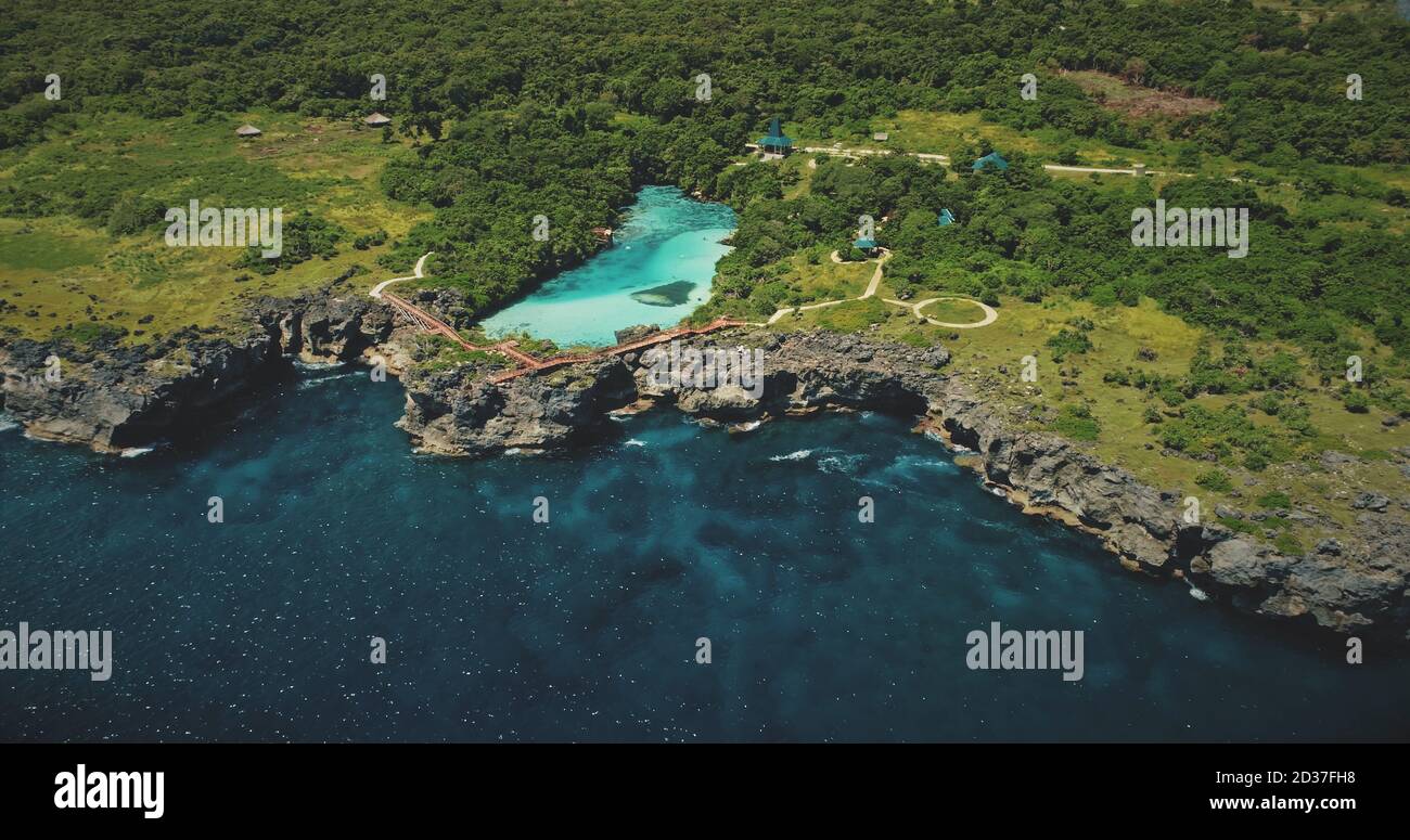 Spiaggia di roccia verde sulla baia dell'oceano con vista aerea del lago di acqua salata tropicale. Nessuno paesaggio naturale tropicale con laguna turchese sulla costa del mare di Weekuri, isola di Sumba, Indonesia Foto Stock