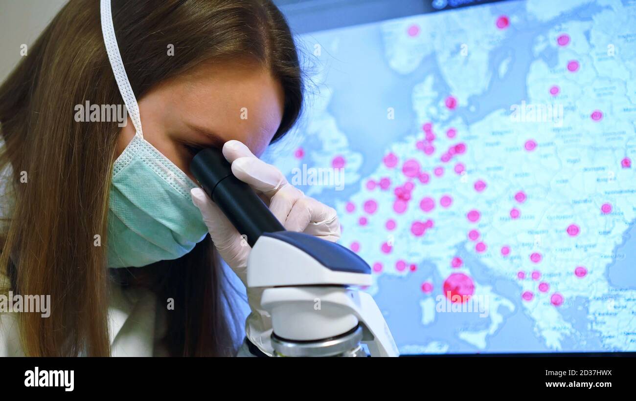 Scienziato in maschera medica in laboratorio. Sulla mappa di sfondo con le infezioni. Foto Stock