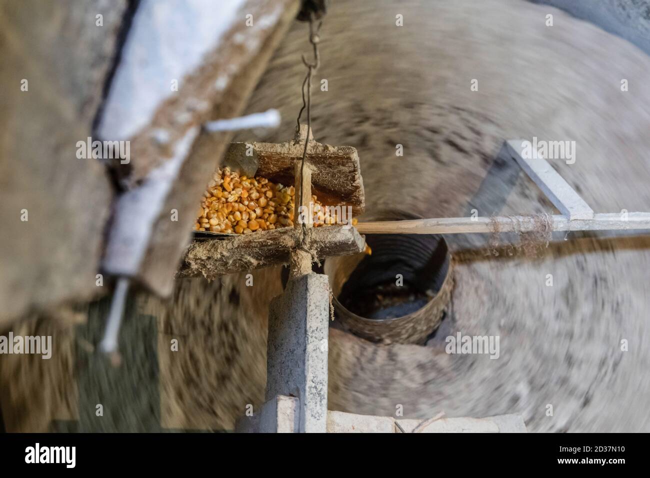 Macinare il mais in un vecchio mulino. Le macine sono filate e macinate mais o farina di grano Foto Stock