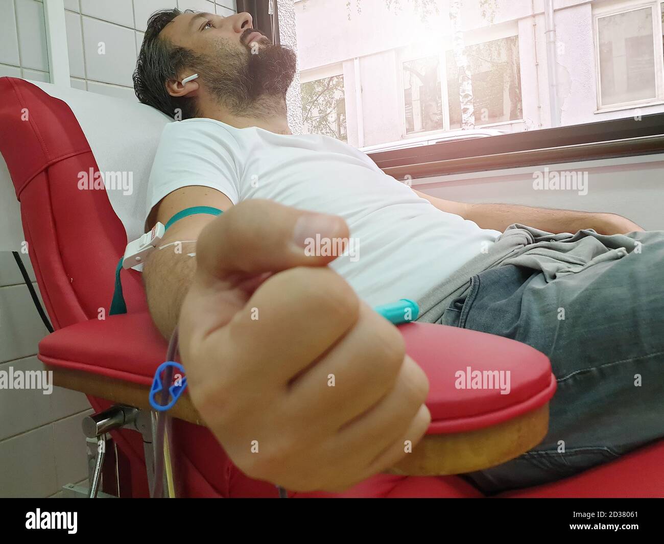 Donatore di sangue seduto in sedia medica mentre dà il sangue. Concetto di donazione di sangue. Concetto che salva una vita Foto Stock