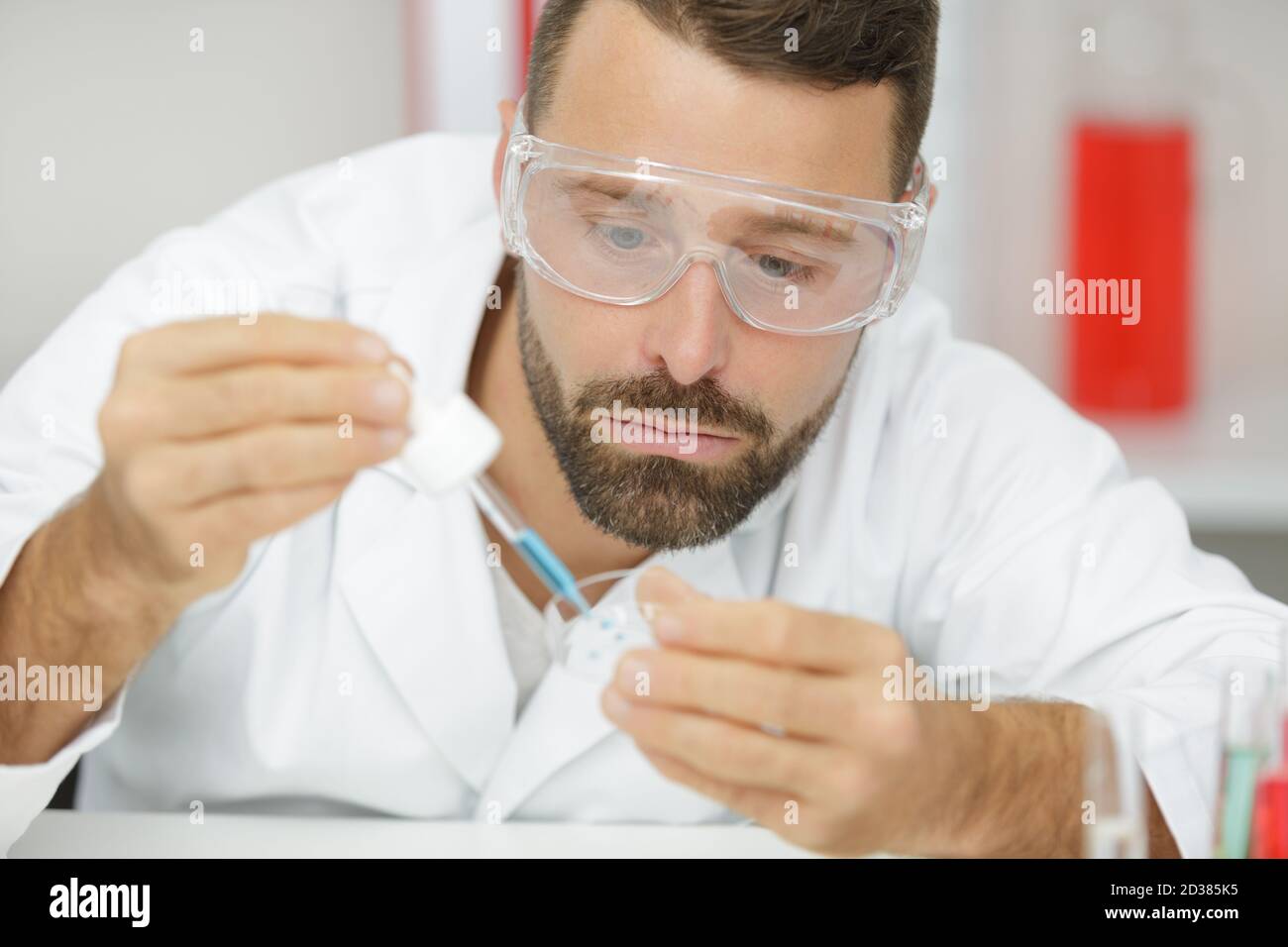 uomo che lavora con la pipetta in laboratorio Foto Stock