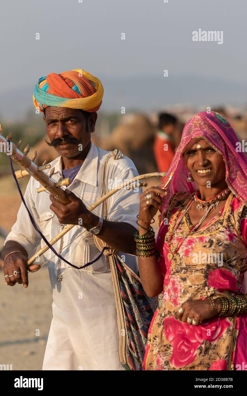 L'uomo e una donna indossano abiti rajasthani suonando violino strumentale al festival Pushkar a Pushkar, Rajasthan, India il 19 novembre 2018 Foto Stock