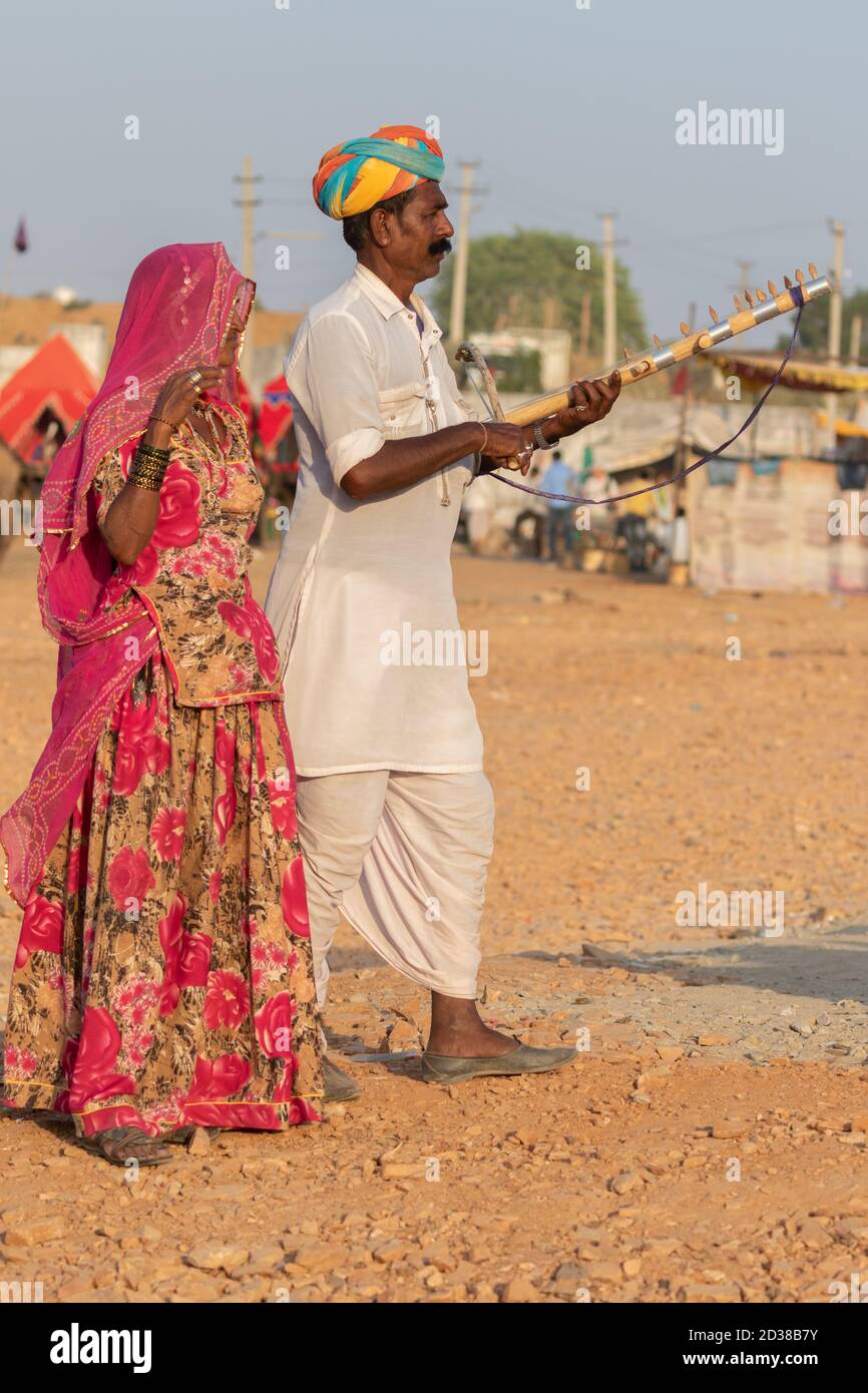 L'uomo e una donna indossano abiti rajasthani suonando violino strumentale al festival Pushkar a Pushkar, Rajasthan, India il 19 novembre 2018 Foto Stock